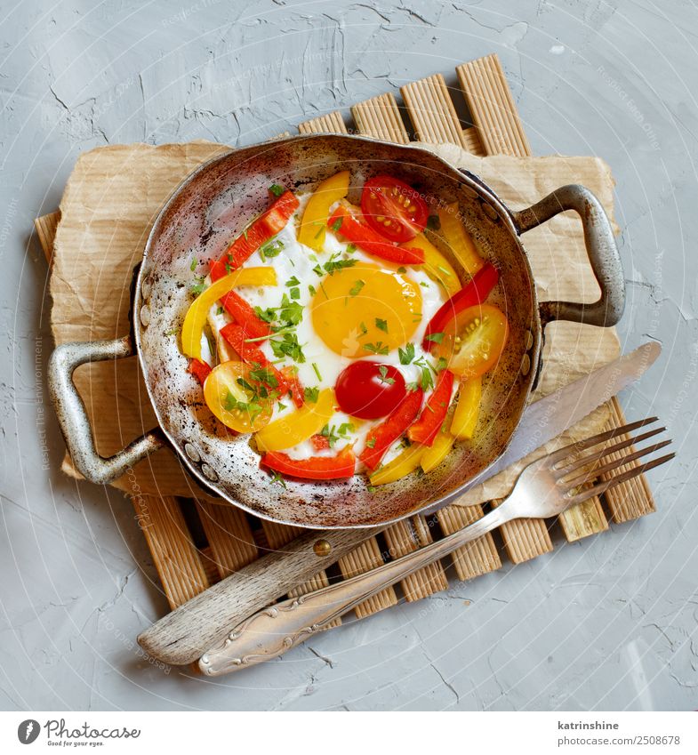 Spiegelei mit Paprika und Tomaten Gemüse Frühstück Pfanne Gabel Tisch frisch hell gelb grau rot Cholesterin kochen & garen Ei fette Nahrung Lebensmittel braten