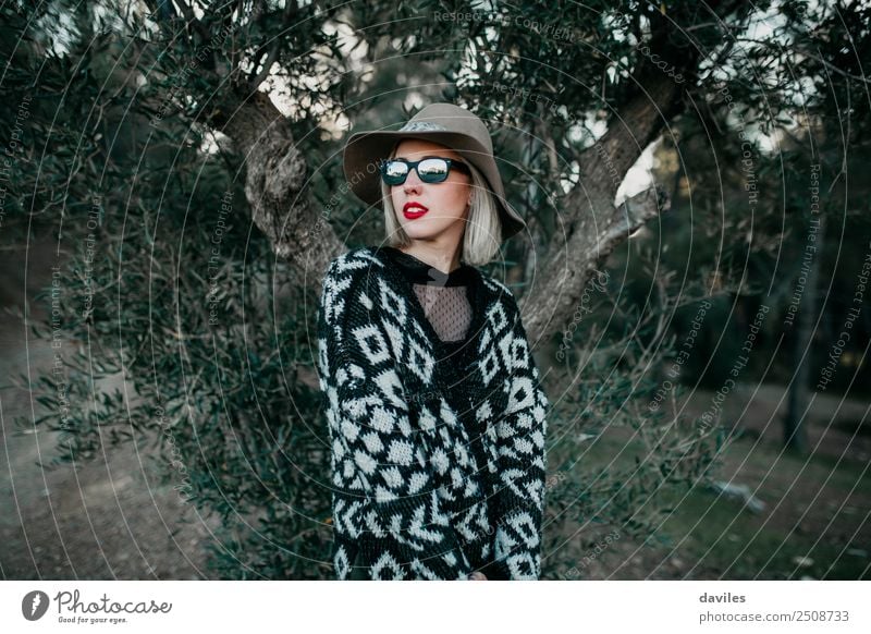 Blonde Frau mit Hut und Sonnenbrille posiert mit einem Olivenbaum im Hintergrund Lifestyle Reichtum elegant Stil schön Ferien & Urlaub & Reisen Ausflug