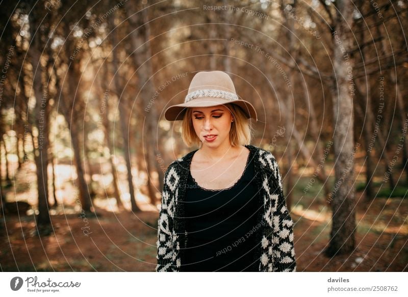 Porträt einer jungen Frau mit Hut, die bei Sonnenuntergang im Wald spazieren geht Lifestyle Freizeit & Hobby Ferien & Urlaub & Reisen Abenteuer Freiheit