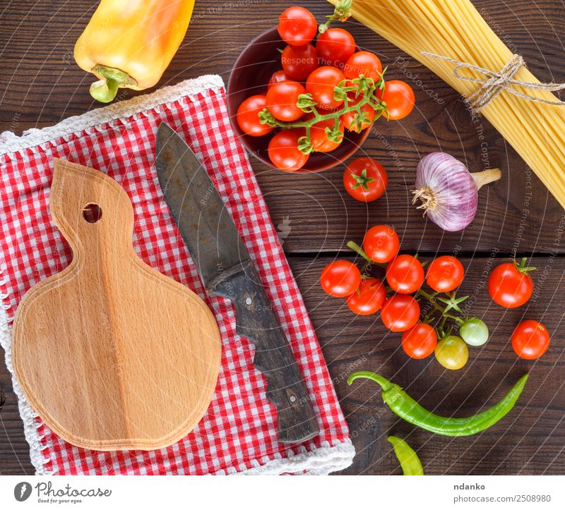 Schneidebrett mit einem Messer Gemüse Teigwaren Backwaren Holz frisch groß lang oben braun gelb rot schwarz Farbe Tradition Spaghetti Spätzle Lebensmittel