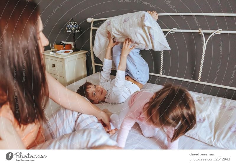 Entspannte Mutter und Söhne spielen über dem Bett. Lifestyle Freude Glück schön Erholung Freizeit & Hobby Spielen Schlafzimmer Kind Baby Junge Frau Erwachsene