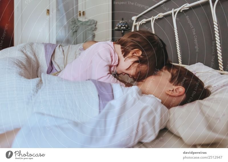 Kleines Mädchen spielt mit dem Jungen über dem Bett. Lifestyle Freude Glück schön Erholung Freizeit & Hobby Spielen Schlafzimmer Kind Baby Frau Erwachsene