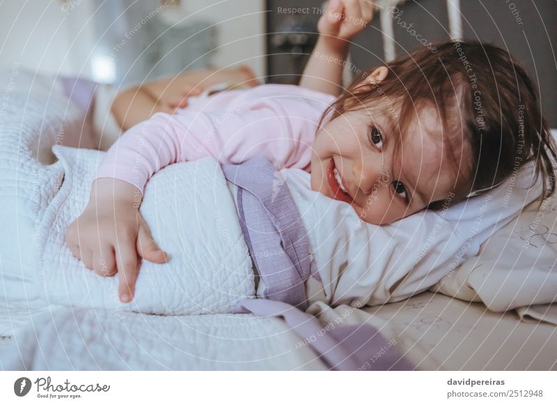 Kleines Mädchen lächelnd über dem Bett liegend Lifestyle Freude Glück Erholung Freizeit & Hobby Spielen Schlafzimmer Kind Mensch Baby Frau Erwachsene Eltern