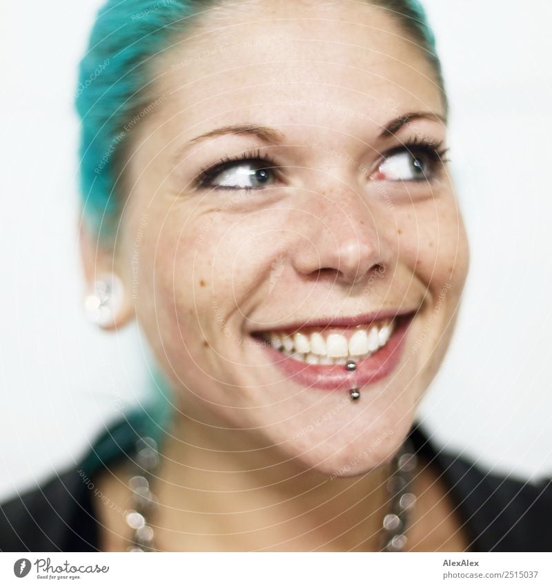 Junge Frau mit türkisen Haaren und Piercings lächelt glücklich Stil exotisch schön Wohlgefühl Jugendliche Gesicht 18-30 Jahre Erwachsene Jacke Schmuck