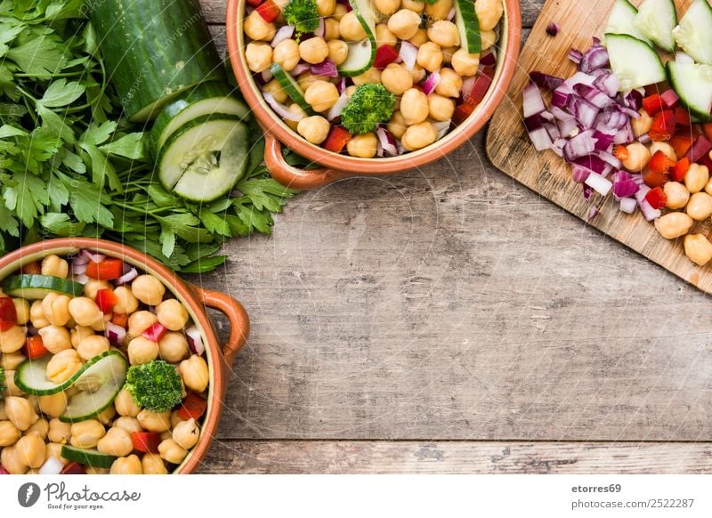 Kichererbsensalat in brauner Schüssel auf Holz Salatbeilage Gurke Salatgurke Zwiebel Brokkoli Gemüse Vegane Ernährung Vegetarische Ernährung Paprika Pfeffer