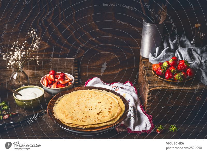 Pfannkuchen auf rustikalem Küchetisch mit Erdbeeren Lebensmittel Frucht Dessert Frühstück Bioprodukte Vegetarische Ernährung Diät Geschirr Teller