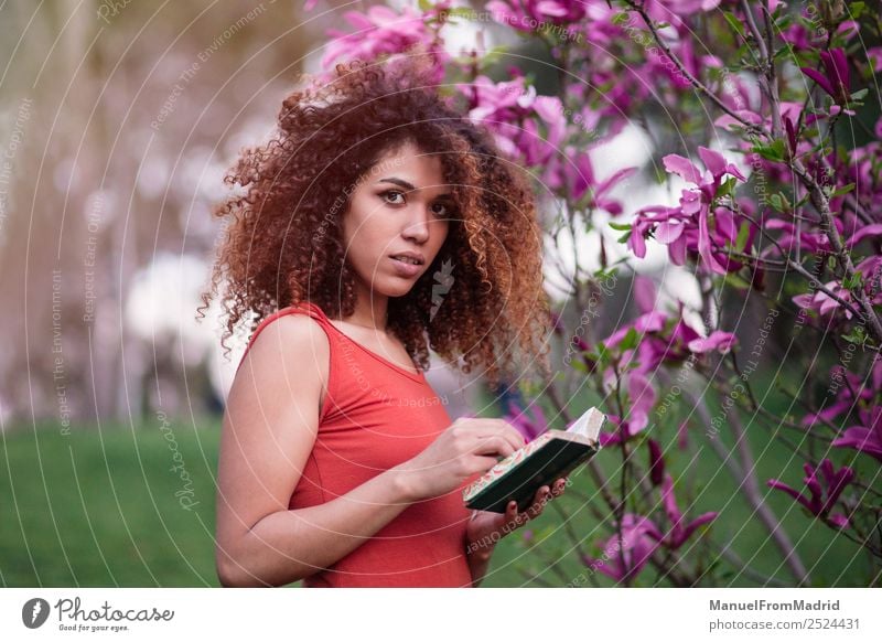 kluge Afrofrau, die ein Buch hält. Lifestyle Glück schön Freizeit & Hobby lesen Sommer Garten Schule lernen Fotokamera Mensch Frau Erwachsene Natur Baum Blume
