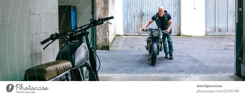 Biker mit dem Motorrad in die Werkstatt Lifestyle Stil Ferien & Urlaub & Reisen Ausflug Mensch Mann Erwachsene Straße Fahrzeug Glatze stehen tragen authentisch