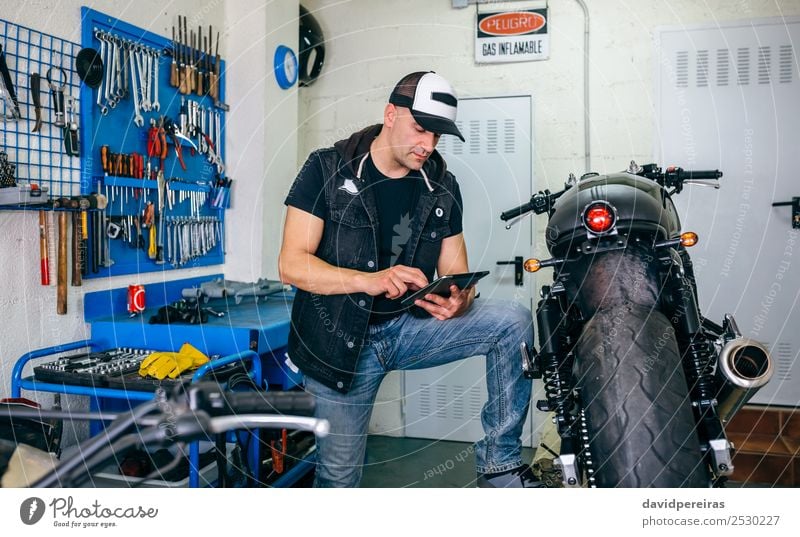 Mechanische Überprüfung von Custom-Motorrädern mit Tablett Lifestyle Stil Arbeit & Erwerbstätigkeit Technik & Technologie Mensch Mann Erwachsene Fahrzeug