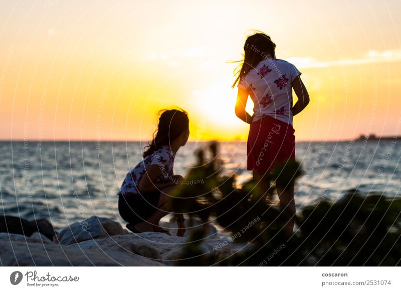 Zwei Mädchen auf dem Breakeater bei Sonnenuntergang Lifestyle Freude Glück schön Erholung Ferien & Urlaub & Reisen Camping Sommer Strand Meer Kind Junge