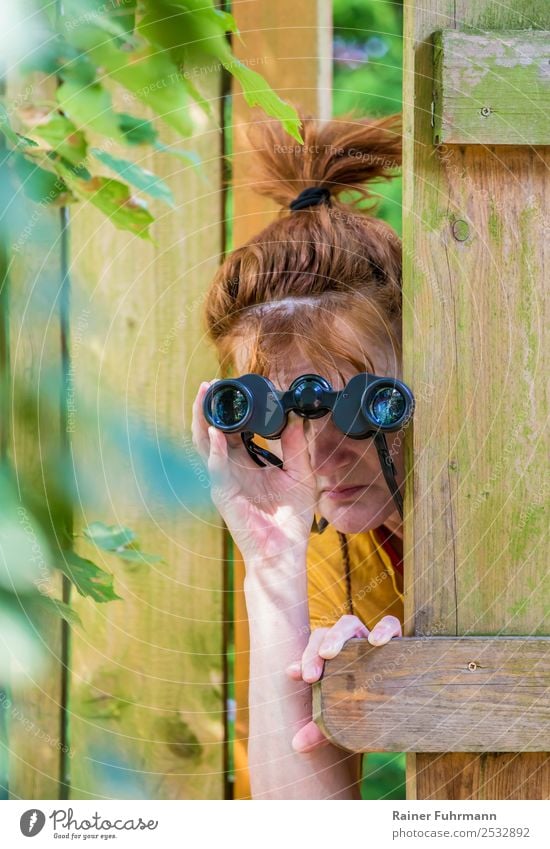 eine neugierige Frau beobachtet mit einem Fernglas Mensch feminin Erwachsene Kopf 1 Umwelt Garten Zaun beobachten Neugier Wachsamkeit Neid "Fernglas
