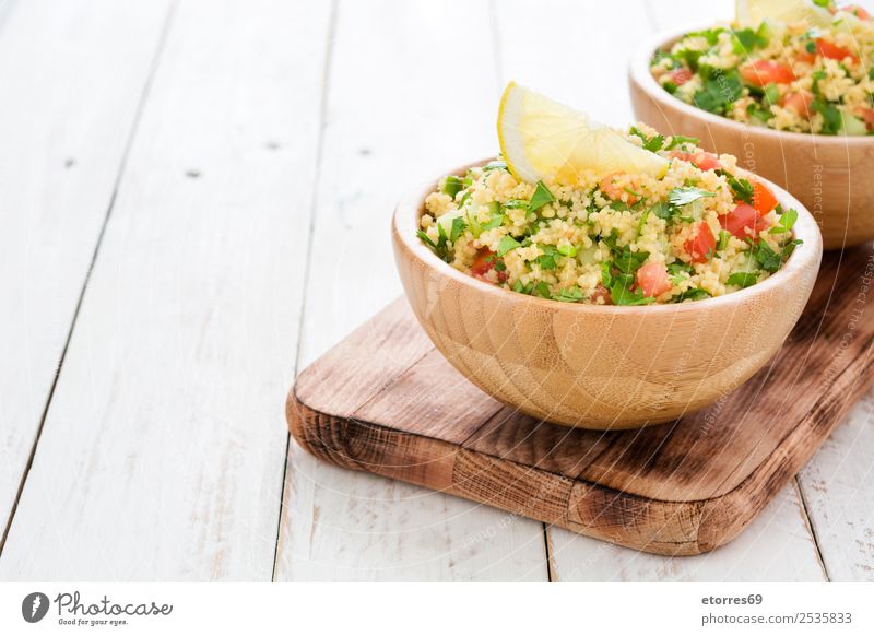 Tabbouleh-Salat mit Couscous auf weißem Holztisch Tisch Salatbeilage Gemüse Tomate Gurke Salatgurke Petersilie Minze Vegane Ernährung Vegetarische Ernährung