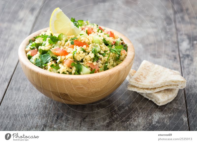 Tabbouleh-Salat und Zutaten auf Holz Tisch Salatbeilage Couscous Gemüse Tomate Gurke Petersilie Minze Vegane Ernährung Vegetarische Ernährung Gesunde Ernährung
