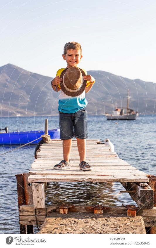 Porträt eines kleinen Kindes auf einem Dock mit einem Hut in der Hand. Lifestyle Glück schön Erholung Freizeit & Hobby Ferien & Urlaub & Reisen Sommer Strand