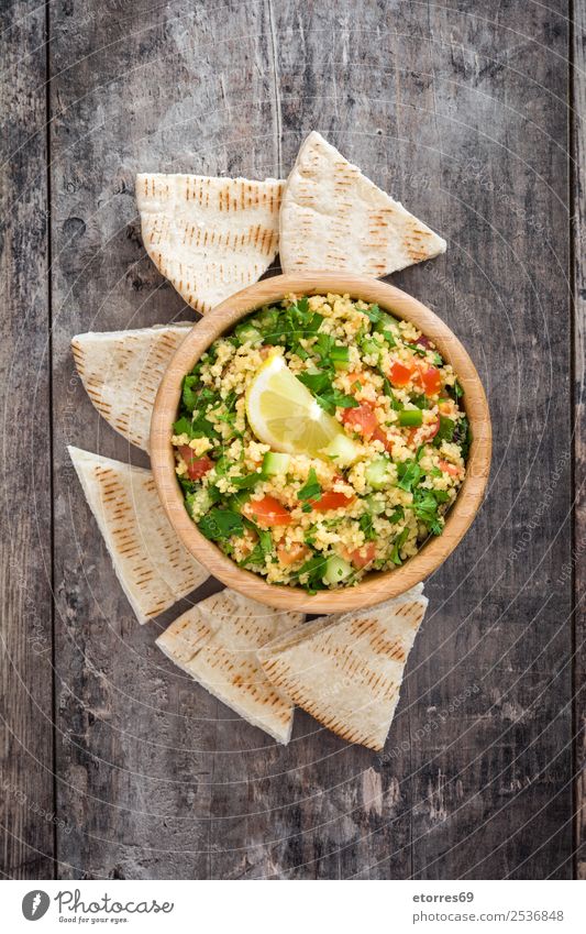 Tabbouleh-Salat mit Couscous auf einem Holztisch Tisch Salatbeilage Gemüse Tomate Gurke Salatgurke Petersilie Minze Vegane Ernährung Vegetarische Ernährung