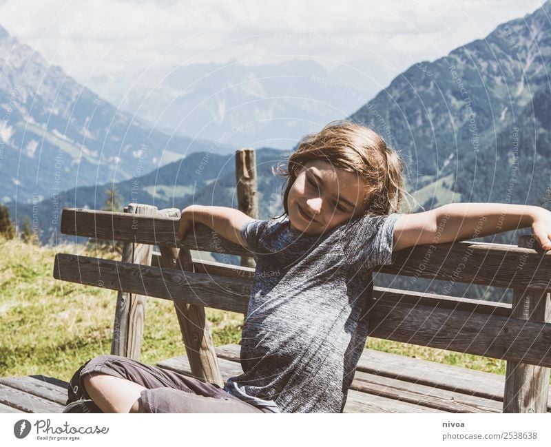Junge sitzt auf Bank im Hintergrund die Berge Ferien & Urlaub & Reisen Ausflug Abenteuer Ferne Freiheit Sommer Sommerurlaub Berge u. Gebirge wandern maskulin