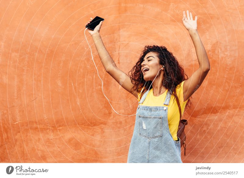 Glückliches arabisches Mädchen beim Musikhören und Tanzen Lifestyle Stil schön Haare & Frisuren Telefon PDA Technik & Technologie Mensch feminin Junge Frau