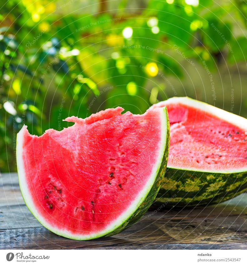 eine reife Wassermelone schneiden Frucht Ernährung Vegetarische Ernährung Tisch Natur Holz Essen frisch natürlich saftig grün rot Farbe Hintergrund Scheibe