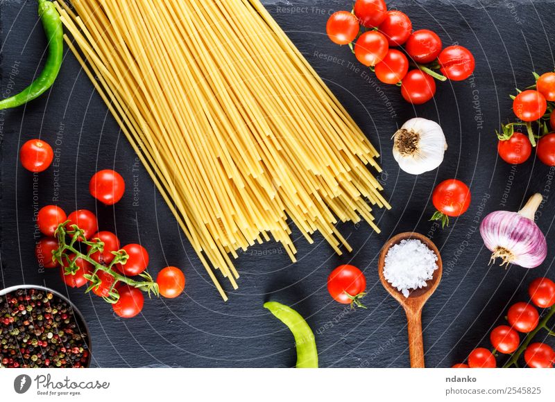 Ungekochte Nudelspaghetti Gemüse Teigwaren Backwaren Holz Linie frisch groß lang oben gelb rot schwarz Farbe Tradition Spaghetti Spätzle Lebensmittel Tomate