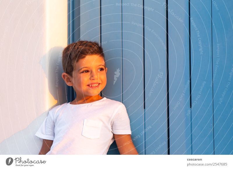 Süßes Kind in der Nähe eines blauen Holzfensters bei Sonnenuntergang Lifestyle Design Glück schön Gesicht Sommer Haus Mensch Baby Kleinkind Junge Kindheit 1