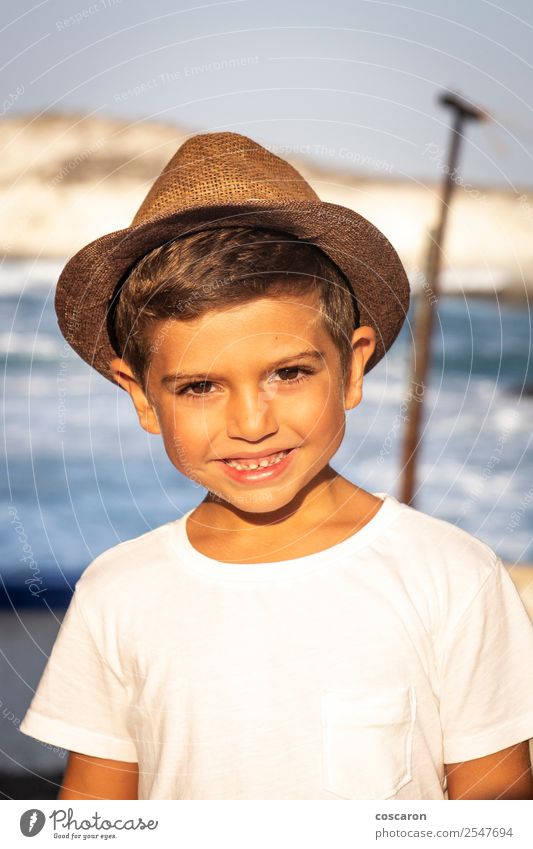 Porträt eines süßen Kindes mit Hut vor einem Meer Lifestyle Freude Glück schön Gesicht Freizeit & Hobby Ferien & Urlaub & Reisen Sommer Sonne Strand Mensch