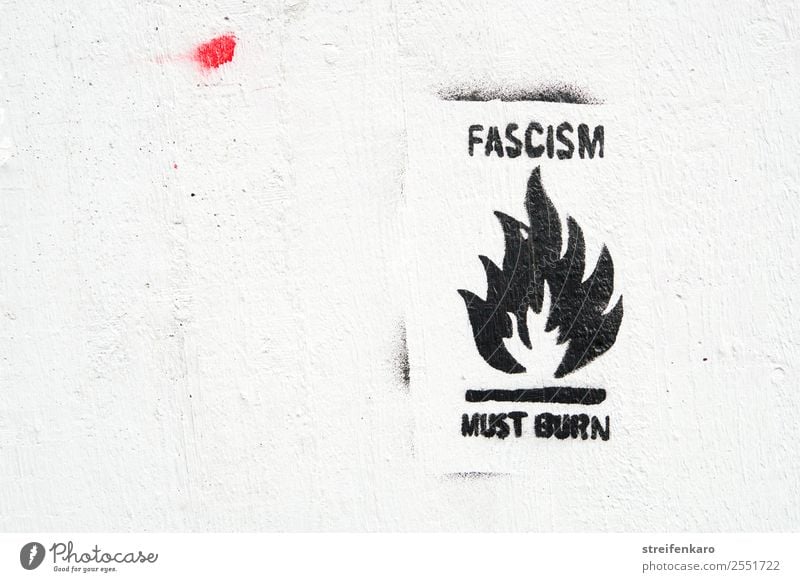 Graffiti gegen Faschismus mit stilisierter Flamme, schwarze Schrift auf weißer Wand Haus Mauer Stein Beton Zeichen Schriftzeichen Aggression bedrohlich dunkel