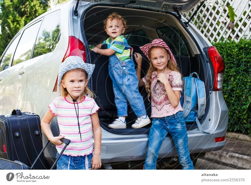 zwei kleine Mädchen und ein Junge, die in der Nähe des Autos stehen. Freude Glück Erholung Freizeit & Hobby Ferien & Urlaub & Reisen Tourismus Ausflug Camping