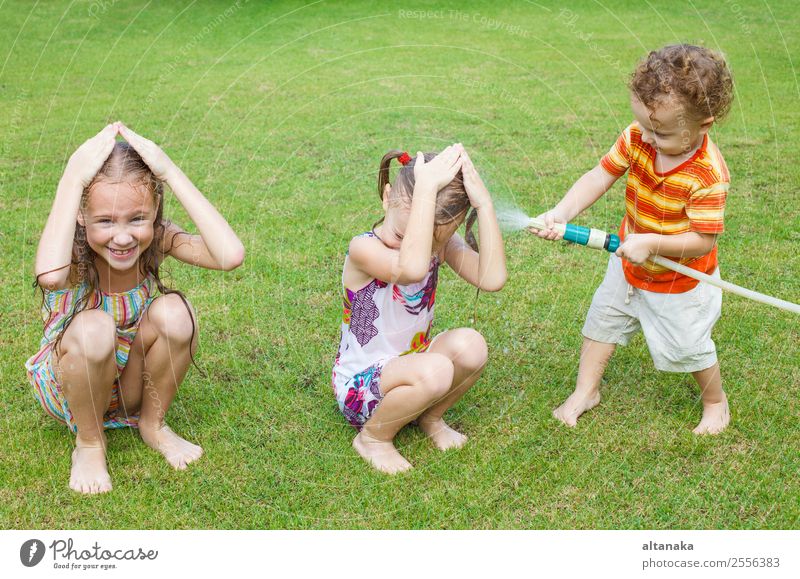 Glückliche Kinder gießen ein Wasser. Freude Freizeit & Hobby Spielen Sommer Haus Garten Mensch Junge Mann Erwachsene Schwester Familie & Verwandtschaft Kindheit