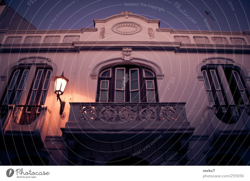 spanischer Balkon Wolkenloser Himmel Haus Fassade Fenster dunkel blau rot weiß ruhig Straßenbeleuchtung Architektur Farbfoto Außenaufnahme Menschenleer