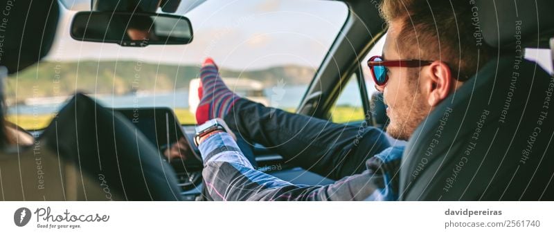 Junger Mann ruht mit den Füßen auf und setzt sich auf das Auto. Lifestyle Freude Glück Erholung Freizeit & Hobby Ferien & Urlaub & Reisen Ausflug Abenteuer