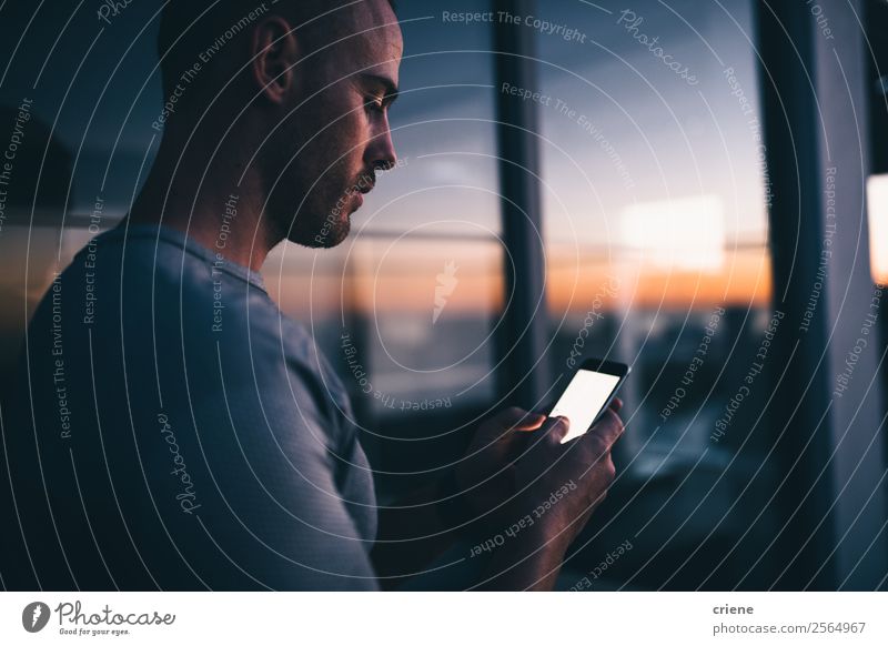 Männer stehen vor dem Fenster mit Smartphone bei Sonnenuntergang. Lifestyle Arbeit & Erwerbstätigkeit Büro Business Telefon PDA Bildschirm Technik & Technologie