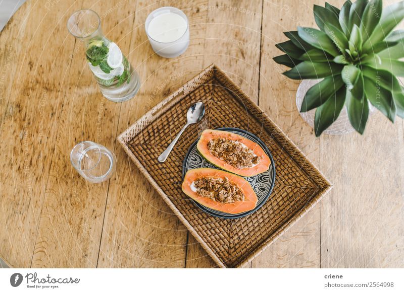 Nahaufnahme der Vorbereitung der Papaya mit Getreide in der Küche Joghurt Frucht Dessert Vegetarische Ernährung Diät exotisch Sommer Tisch Natur Pflanze Blatt