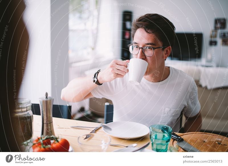 junger asiatischer Mann beim Kaffee trinken und Frühstücken Gemüse Essen Freude schön Stuhl Tisch Küche sprechen Mensch Frau Erwachsene Familie & Verwandtschaft
