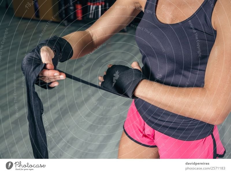 Frau wickelt die Hände mit Verbänden ein, bevor sie das Boxtraining beginnt. schön Körper Sport Mensch Erwachsene Hand Handschuhe Fitness authentisch Erotik