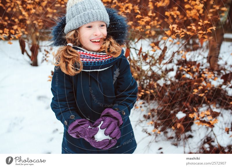 Winterportrait eines glücklichen Kindes Mädchens beim Schneeballspielen Lifestyle Freude Spielen Ferien & Urlaub & Reisen Garten Natur Wetter Wärme Park