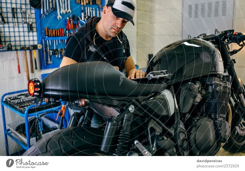Mechanische Überprüfung des Motorrads Lifestyle Stil Arbeit & Erwerbstätigkeit Mensch Mann Erwachsene Fahrzeug authentisch retro schwarz Mechaniker