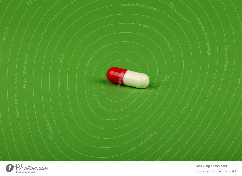 Nahaufnahme einer roten und weißen Gelkappe Pille der Medizin auf Grün Gesundheit Gesundheitswesen Behandlung Rauschmittel Medikament natürlich weich grün Farbe