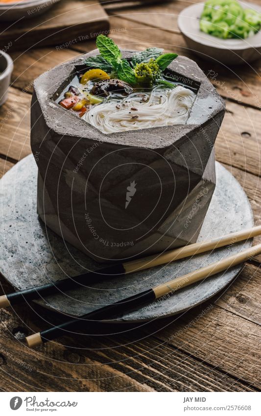 Geometrische Schale aus asiatischer Nudelsuppe mit Essstäbchen Lebensmittel Fleisch Gemüse Teigwaren Backwaren Suppe Eintopf Mittagessen Abendessen