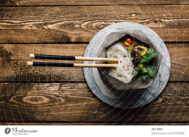 Geometrische Schale aus asiatischer Nudelsuppe mit Essstäbchen Lebensmittel Fleisch Gemüse Suppe Eintopf Mittagessen Abendessen Asiatische Küche Teller