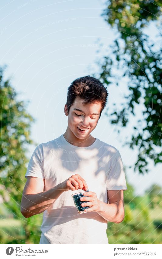 Kleiner Junge genießt es, die frischen Blaubeeren zu essen. Lebensmittel Frucht Ernährung Essen Bioprodukte Vegetarische Ernährung Glas Lifestyle Freude Sommer