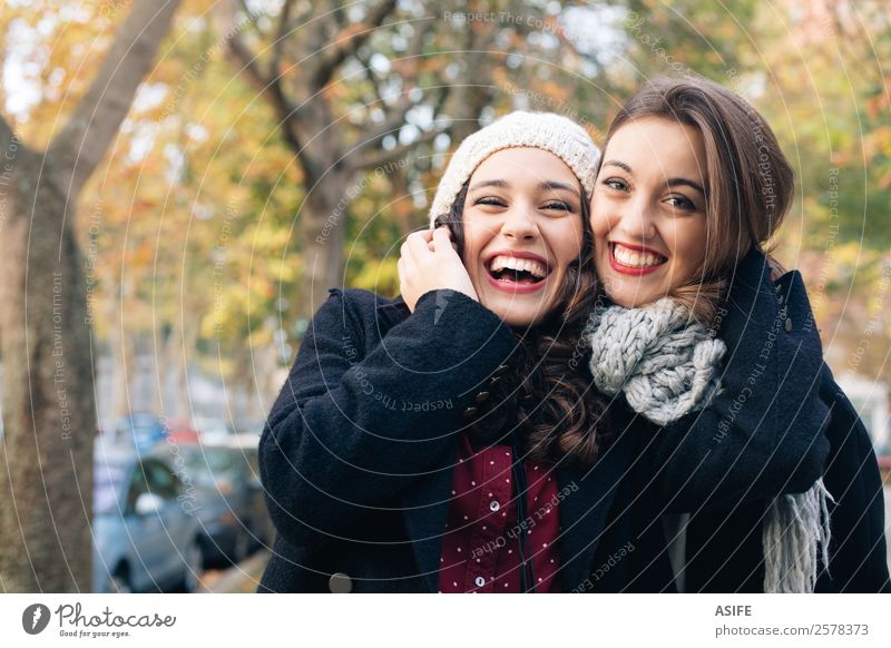 Lachende beste Freunde beim Umarmen im Freien im Herbst Lifestyle Freude Glück schön Winter Frau Erwachsene Freundschaft Jugendliche Park Mode Schal Lächeln