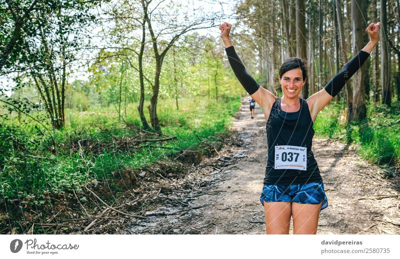 Junge Frau gewinnt Trail Race Lifestyle Glück Feste & Feiern Sport Erfolg Mensch Erwachsene Natur Baum Wald Wege & Pfade Turnschuh Fitness Lächeln