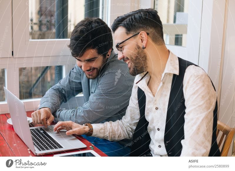 Zwei junge moderne Männer mit einem Laptop und einem Tablett in einer Café-Bar Kaffee Freude Glück lernen Arbeit & Erwerbstätigkeit Business Sitzung Computer
