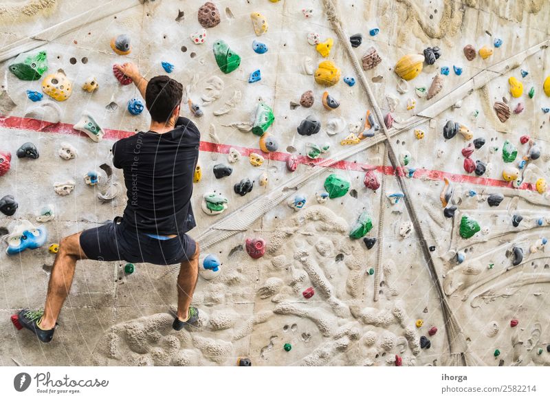 Ein Mann übt das Klettern an einer künstlichen Wand in Innenräumen. Lifestyle Freude Freizeit & Hobby Sport Bergsteigen Junger Mann Jugendliche Erwachsene 1
