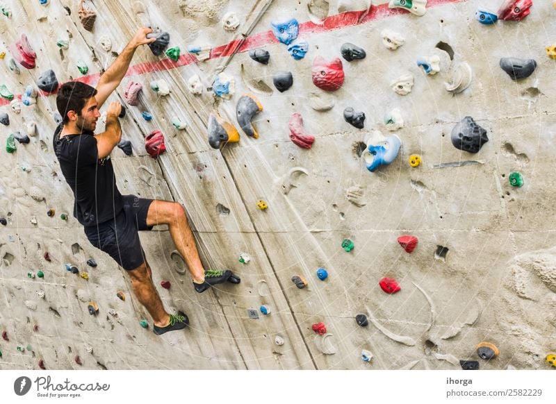 Ein Mann übt das Klettern an einer künstlichen Wand in Innenräumen. Lifestyle Freude Freizeit & Hobby Sport Bergsteigen Erwachsene 1 Mensch 18-30 Jahre