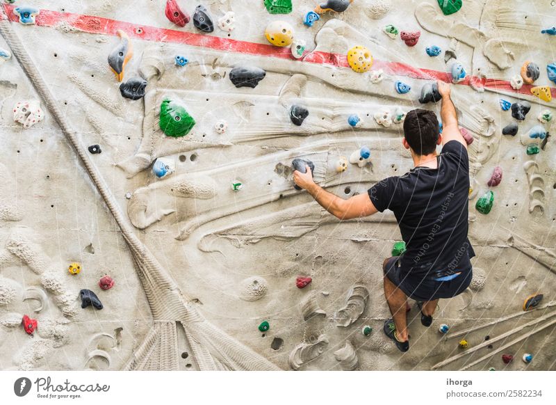 Ein Mann übt das Klettern an einer künstlichen Wand in Innenräumen. Lifestyle Freude Freizeit & Hobby Sport Bergsteigen Erwachsene Hand Finger Fuß 1 Mensch