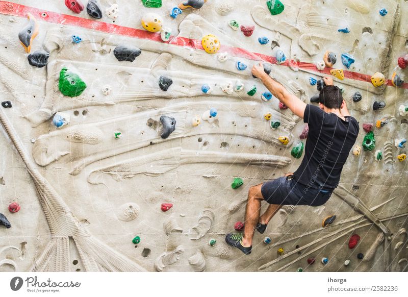 Ein Mann übt das Klettern an einer künstlichen Wand in Innenräumen. Lifestyle Freude Freizeit & Hobby Sport Bergsteigen Erwachsene Hand Finger Fuß 1 Mensch