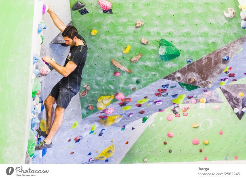 Ein Mann übt das Klettern an einer künstlichen Wand in Innenräumen. Lifestyle Freude Freizeit & Hobby Sport Bergsteigen Junger Mann Jugendliche Erwachsene Hand