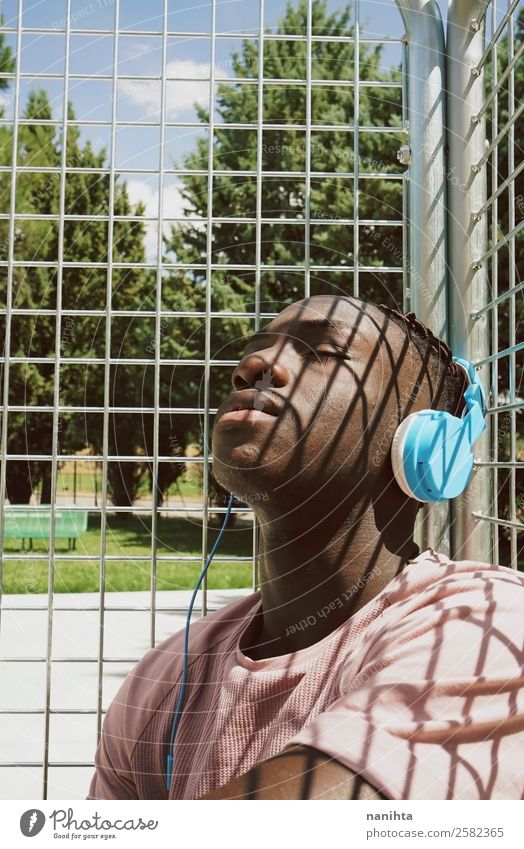 Junger Mann genießt Sonne und Musik Lifestyle Stil Design Sinnesorgane Erholung Meditation Freizeit & Hobby Headset Kopfhörer Technik & Technologie