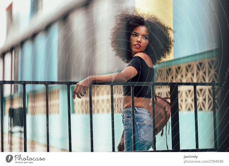 Junge gemischte Frau mit Afrohaar, die auf der Straße steht. Lifestyle Stil schön Haare & Frisuren Gesicht Mensch feminin Junge Frau Jugendliche Erwachsene 1